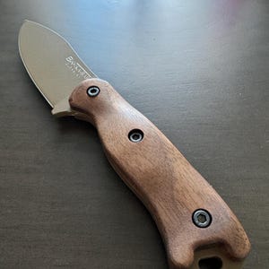 May include: A brown wooden handled knife with a silver blade. The blade has the text "BK14" and "STAINLESS" engraved on it.