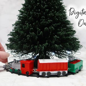 Könnte beinhalten: Ein Miniatur-Zugsatz mit einem roten Schlusslicht, einer grauen Lokomotive und einem roten Güterwagen mit weißem Dach. Der Zug ist auf einer Schiene um einen kleinen künstlichen Weihnachtsbaum herum aufgebaut. Der Text "Digitaler Download nur" ist im Hintergrund sichtbar.