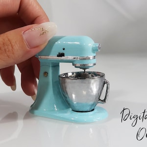Peut inclure: Un robot pâtissier miniature de couleur bleu clair avec un bol en argent. Le robot est assez petit pour tenir dans la paume de la main. Fichier numérique uniquement.