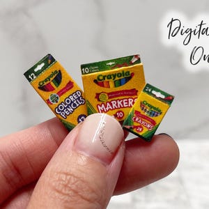 May include: Miniature Crayola stationery set, featuring boxes of coloured pencils, markers, and crayons. The boxes are yellow with the Crayola logo and rainbow details. The text "Digital File Only" is visible.