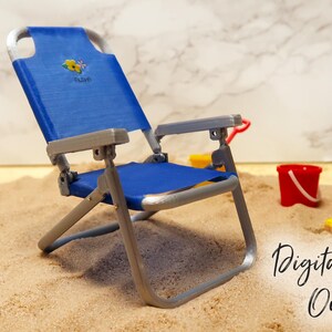 May include: A blue and silver folding beach chair with a floral design on the back. The chair is sitting on a sandy surface. "Digital File Only" is written on the sand.