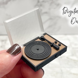 Op de afbeelding: Miniatuur zwarte en bruine platenspeler met een zilveren deksel. De platenspeler heeft een zwarte plaat en toonarm. De tekst "Digital File Only" staat in cursief rechtsboven.