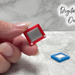 May include: Miniature red Etch-A-Sketch toy with a silver screen and white knobs. A blue version of the toy is also visible. The image includes the text "Digital File Only".
