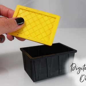 May include: A black plastic storage bin with a yellow lid. The lid has a diamond pattern and is being lifted off the bin. The text "Digital File Only" is visible in the lower right corner of the image.