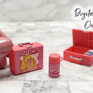 Puede incluir: Una maleta miniatura rosa de Barbie con un gráfico de un personaje rubio, un pequeño termo rosa de Barbie y un estuche de plástico rosa abierto que contiene una botella diminuta. El texto Digital File Only es visible en la esquina superior.