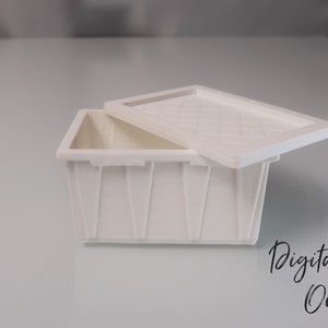 May include: A white plastic storage bin with a lid. The lid has a textured pattern and is slightly ajar. The bin is empty.