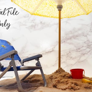 May include: A blue beach chair with a yellow and blue design sits in the sand under a yellow and white striped beach umbrella. There is a red bucket and a yellow bucket with a red shovel in the sand.