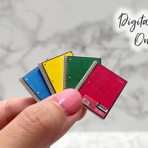 May include: Miniature notebooks in blue, yellow, green, and red, held in hand. Each notebook has a silver spiral binding and a white dot. The image includes the text "Digital File Only".