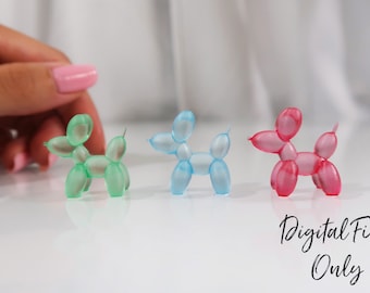 May include: Three balloon animal dog figurines in green, blue, and pink. The figurines are made of a translucent material and are arranged in a row on a white surface.