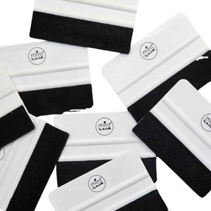 Puede incluir: Un conjunto de seis herramientas de aplicaci&oacute;n de pl&aacute;stico blanco con bordes de fieltro negro. Cada herramienta tiene un logotipo circular con el texto "mint by muelle" impreso en &eacute;l.