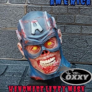 May include: A handmade latex mask of a zombie Captain America. The mask is blue, red, and white with a skull-like face and glowing yellow eyes. The mask is labeled "Zombie Captain America" and "Handmade Latex Mask".