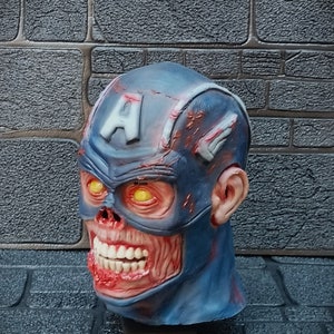 May include: A blue and red zombie Captain America mask with glowing yellow eyes. The mask is made of plastic and has a detailed design.