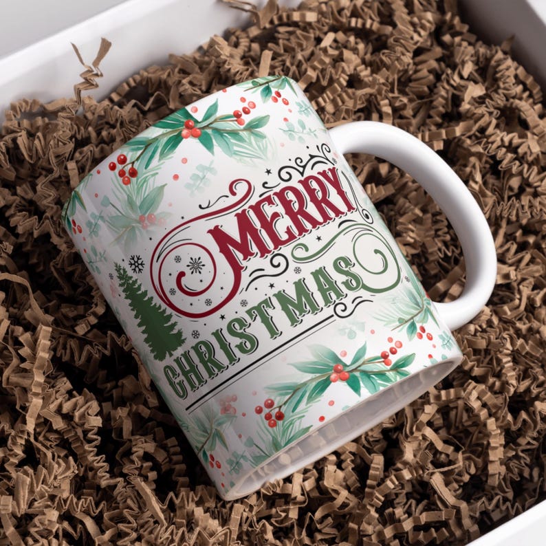 May include: White ceramic mug with a "Merry Christmas" design. The mug features a festive design with red berries, green leaves, and a Christmas tree. The mug is nestled in brown packing material inside a white box.