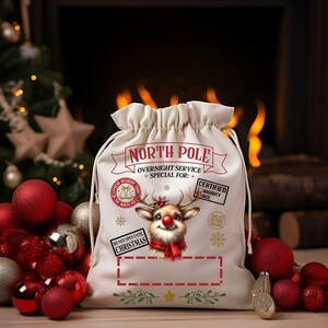 Puede incluir: Un saco de Santa Claus de lona blanca con una ilustraci&oacute;n de reno rojo y el texto "NORTH POLE OVERNIGHT SERVICE SPECIAL FOR: CERTIFIED NAUGHTY NICE DO NOT OPEN UNTIL CHRISTMAS".