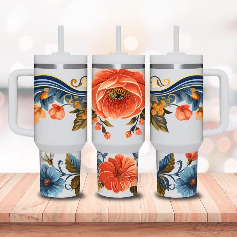 May include: Three white travel mugs with floral designs. The mugs have a handle and a straw. The floral designs feature orange, blue, and green colors.