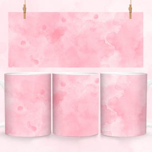 May include: Three white ceramic mugs with a pink watercolor design. The design features light and dark pink shades of watercolor paint.