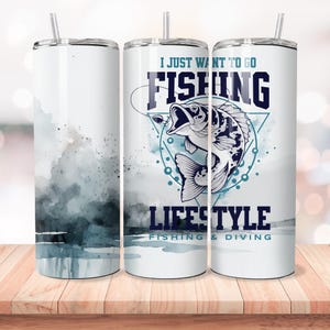 Pu&ograve; includere: Un bicchiere in acciaio inossidabile bianco con un design ad acquerello blu e grigio. Il bicchiere ha una cannuccia e dice "I Just Want To Go Fishing Lifestyle Fishing & Diving".