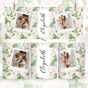 May include: A white mug with a floral pattern featuring pink and blue flowers. The mug has a photo of a family of three in a white frame. The name "Elizabeth" is written in cursive on the mug.