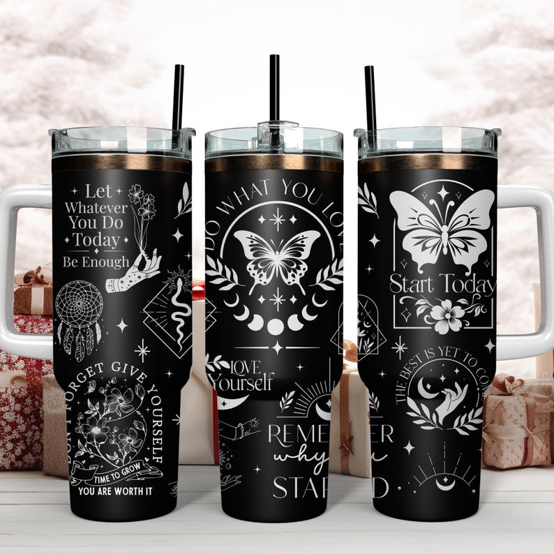 Puede incluir: Tres vasos de acero inoxidable negro con dise&ntilde;os blancos. Los vasos presentan citas inspiradoras, mariposas y fases lunares. Las citas incluyen "Deja que todo lo que hagas hoy sea suficiente", "Haz lo que amas" y "Comienza hoy Lo mejor est&aacute; por venir".