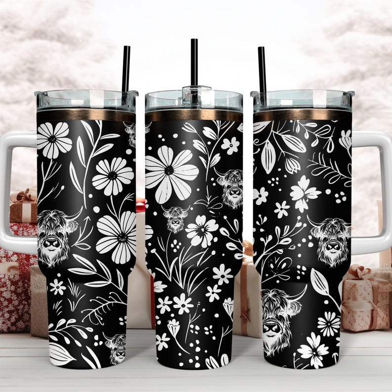 May include: Three black and white stainless steel tumblers with a floral and highland cow design. The tumblers have a gold lid and a straw.