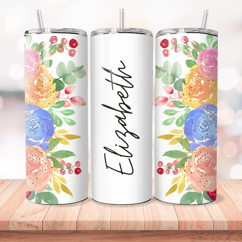 Puede incluir: Tres vasos de acero inoxidable con fondo blanco y un dise&ntilde;o floral en tonos rosa, amarillo, azul y verde. El vaso del medio tiene el nombre "Elizabeth" escrito en cursiva negra.