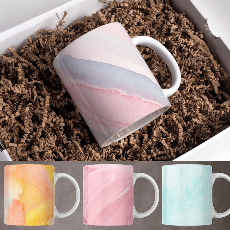 May include: Set of four ceramic mugs with watercolor-style designs. The mugs feature abstract patterns in shades of pink, blue, and yellow.