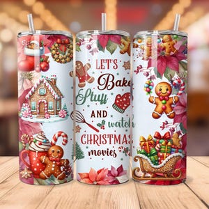 Könnte beinhalten: Drei Edelstahlbecher mit Weihnachtsmotiv. Die Becher haben einen weißen Hintergrund mit roten Weihnachtssternen, Lebkuchenmännern und dem Text "Let's Bake Stuff and watch Christmas movies".