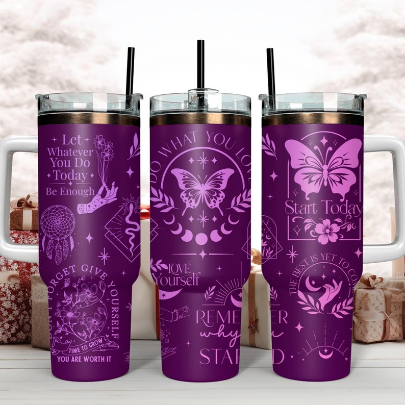 Puede incluir: Tres vasos de acero inoxidable de color morado con frases motivacionales y dise&ntilde;os de mariposas. Las frases incluyen "Haz lo que amas", "Comienza hoy" y "Recuerda por qu&eacute; empezaste".