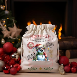 Puede incluir: Un saco de Santa de lona blanca con una ilustraci&oacute;n de mu&ntilde;eco de nieve. El saco tiene el texto "North Pole Overnight Service Special For:" y "Certified Naughty Nice" con una casilla de verificaci&oacute;n junto a cada opci&oacute;n. El mu&ntilde;eco de nieve lleva gafas de sol y sostiene una copa de champ&aacute;n. El saco tiene un letrero rojo y blanco que dice "Do Not Open Until Christmas".