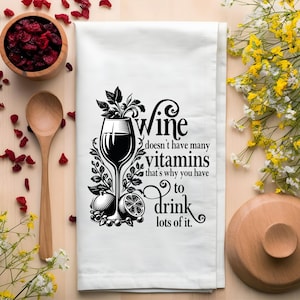 Puede incluir: Una toalla de cocina blanca con una ilustraci&oacute;n en blanco y negro de una copa de vino y el texto "El vino no tiene muchas vitaminas, por eso tienes que beber mucho."