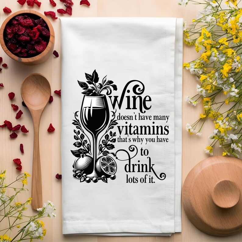 Puede incluir: Una toalla de cocina blanca con una ilustraci&oacute;n en blanco y negro de una copa de vino y el texto "El vino no tiene muchas vitaminas, por eso tienes que beber mucho."
