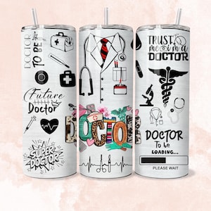May include: Three white tumblers with different designs related to the medical profession. The first tumbler has the text "DOCTOR TO BE" and "Future Doctor" with medical symbols. The second tumbler has a doctor's coat, stethoscope, and the word "DOCTOR" in colourful letters. The third tumbler has the text "TRUST me I'm a DOCTOR" and a caduceus symbol.
