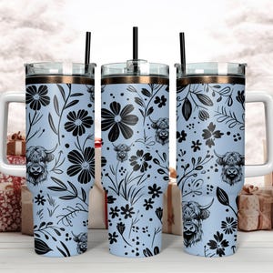 May include: Three stainless steel tumblers with lids and straws. The tumblers are light blue with a black floral pattern and black highland cow silhouettes.