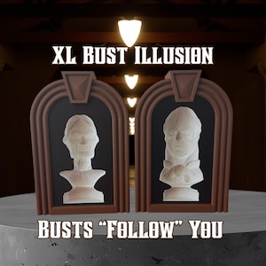 May include: Two white bust sculptures with detailed faces are displayed in brown frames against a black background. The frames are set on a gray surface. The text "XL BUST ILLUSION" and "BUSTS 'FOLLOW' YOU" are displayed above and below the busts.