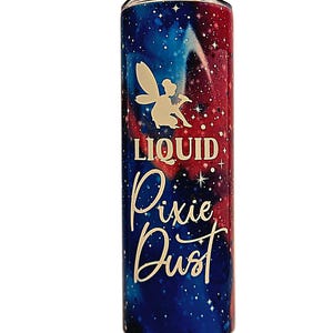 May include: A stainless steel tumbler with a galaxy-themed design in shades of blue and red. The tumbler features a white silhouette of a fairy and the words "LIQUID Pixie Dust" in a whimsical font.