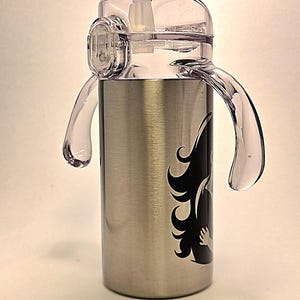 May include: Stainless steel water bottle with a clear plastic lid and handles. The bottle features a black graphic design on the side. The lid has a built-in straw and a locking mechanism. The handles are clear and curved.