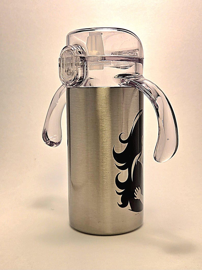 May include: Stainless steel water bottle with a clear plastic lid and handles. The bottle features a black graphic design on the side. The lid has a built-in straw and a locking mechanism. The handles are clear and curved.
