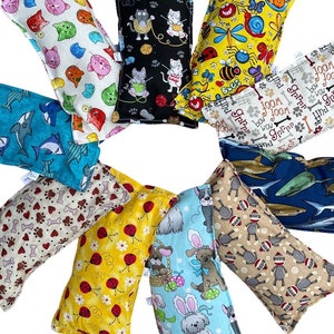 May include: Assortment of colorful fabric pillow-shaped toys with various animal and insect designs. The pillows are arranged in a circle on a white background.