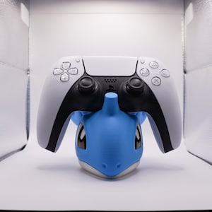 May include: A white and black PlayStation 5 controller with blue and white character figurine.