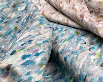 May include: Close-up of a fabric with a blue and white abstract pattern. The fabric is soft and has a subtle sheen.