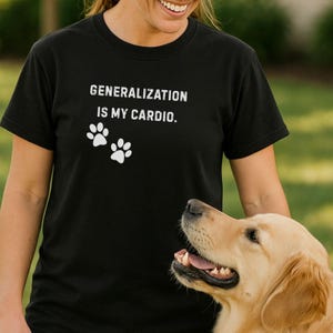May include: Black t-shirt with the text "GENERALIZATION IS MY CARDIO" and two white paw prints. A golden retriever dog is in the foreground. The shirt is worn by a person.