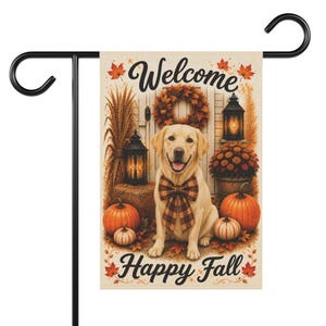 May include: A rectangular garden flag featuring a yellow Labrador retriever wearing a plaid bow tie, surrounded by pumpkins, lanterns, wheat, and a wreath. The text Welcome is printed at the top and Happy Fall is printed at the bottom.