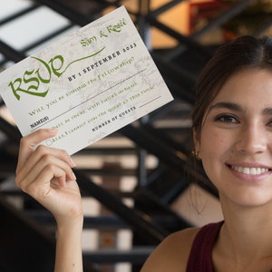 May include: A white RSVP card with green text and a map-like background. The text reads "Sam & Reste BY: SEPTEMBER 2023 WILL you BE JOINING THE Fellowship? NAME(S) hall be there, with sword in hand ALAS, I CANNOT join the quest at this time NUMBER OF GUESTS"
