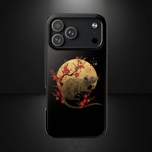 Może przedstawiać: Czarne etui na telefon z brązowym szczurem na tle złotego księżyca i czerwonych kwiatowych akcentów. Projekt inspirowany jest sztuką japońską. Etui ma błyszczące wykończenie i moduł aparatu z trzema obiektywami.