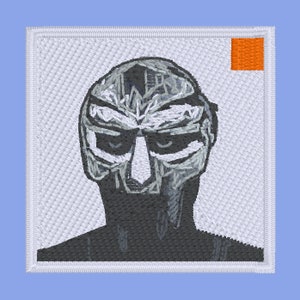 Może przedstawiać: Biała haftowana łatka z czarno-szarym rysunkiem postaci w masce. Łatka ma mały pomarańczowy kwadrat w prawym górnym rogu.