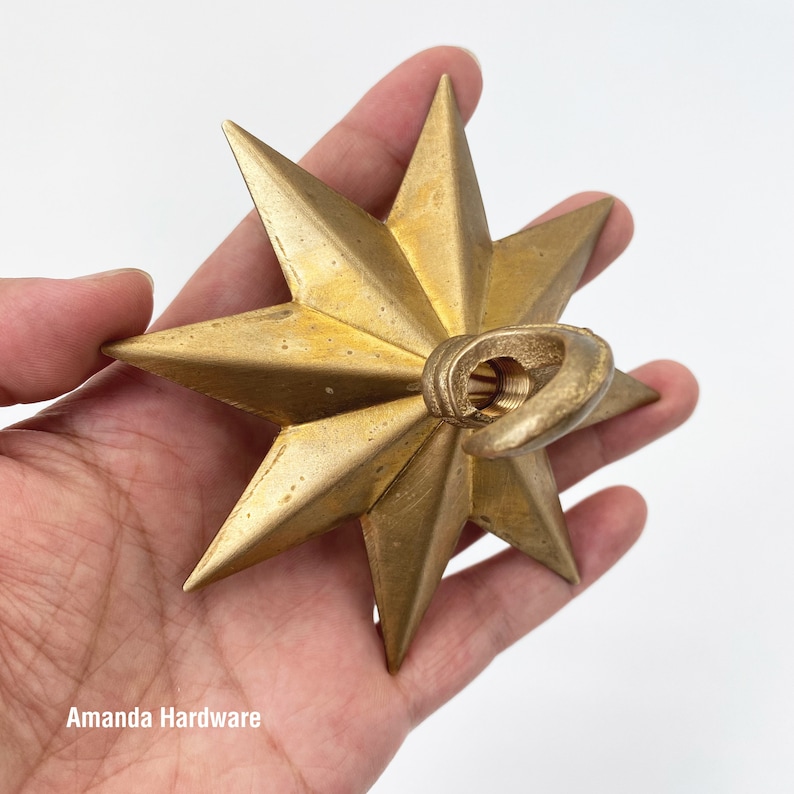 Brass Star Hook For Hanging Planters, Wind Chimes, Swag Pendent Lights and Keys - Decorative Open Hook For Home Ceiling & Wall Decor - Image showing hand holding star hook - AmandaHardware.etsy.com
