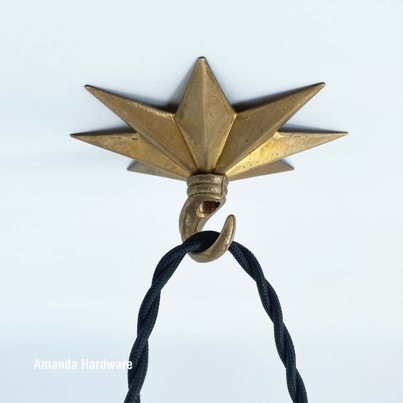 Brass Star Hook For Hanging Planters, Wind Chimes, Swag Pendent Lights and Keys - Decorative Open Hook For Home Ceiling & Wall Decor - Image showing star hook mounted on ceiling with black twisted cord hanging on it - AmandaHardware.etsy.com