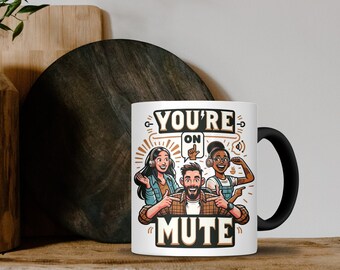Op de afbeelding: Witte keramische mok met een zwart handvat. De mok heeft de tekst "YOU'RE ON MUTE" en een cartoon illustratie van drie mensen met een koptelefoon. Het ontwerp bevat een tekstballon en geluidsgolf iconen.