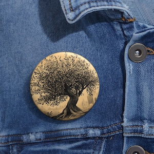 May include: A round button featuring a detailed illustration of a tree with a thick trunk and many branches. The tree is drawn in shades of brown and black against a light brown background.