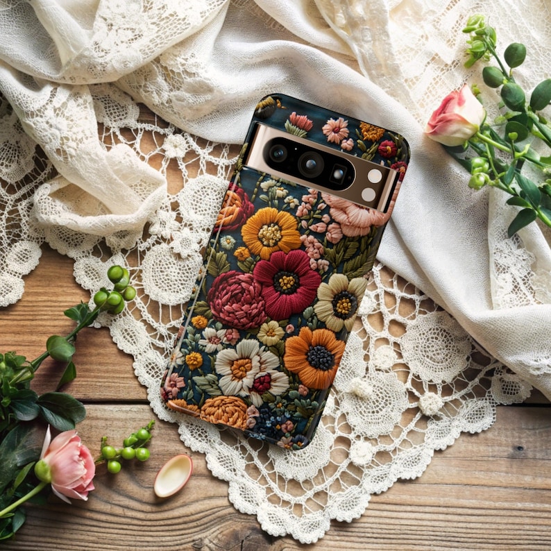 Puede incluir: Una funda de tel&eacute;fono negra con un dise&ntilde;o floral. La funda presenta una variedad de flores coloridas, incluyendo rojas, rosas, amarillas y blancas. La funda del tel&eacute;fono tiene un borde dorado.